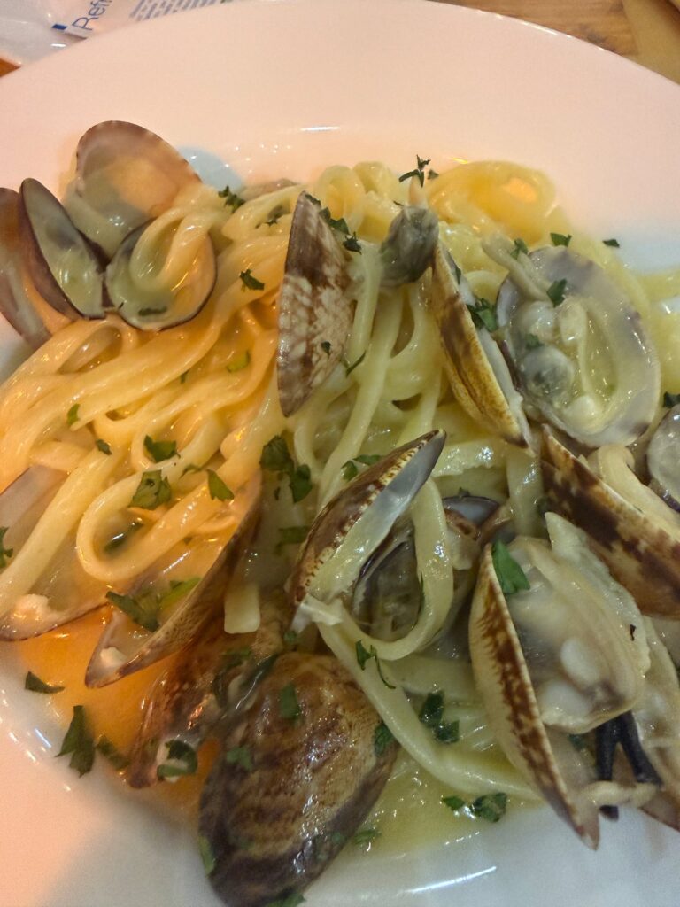 Makaron z małżami vongole i natką pietruszki na talerzu