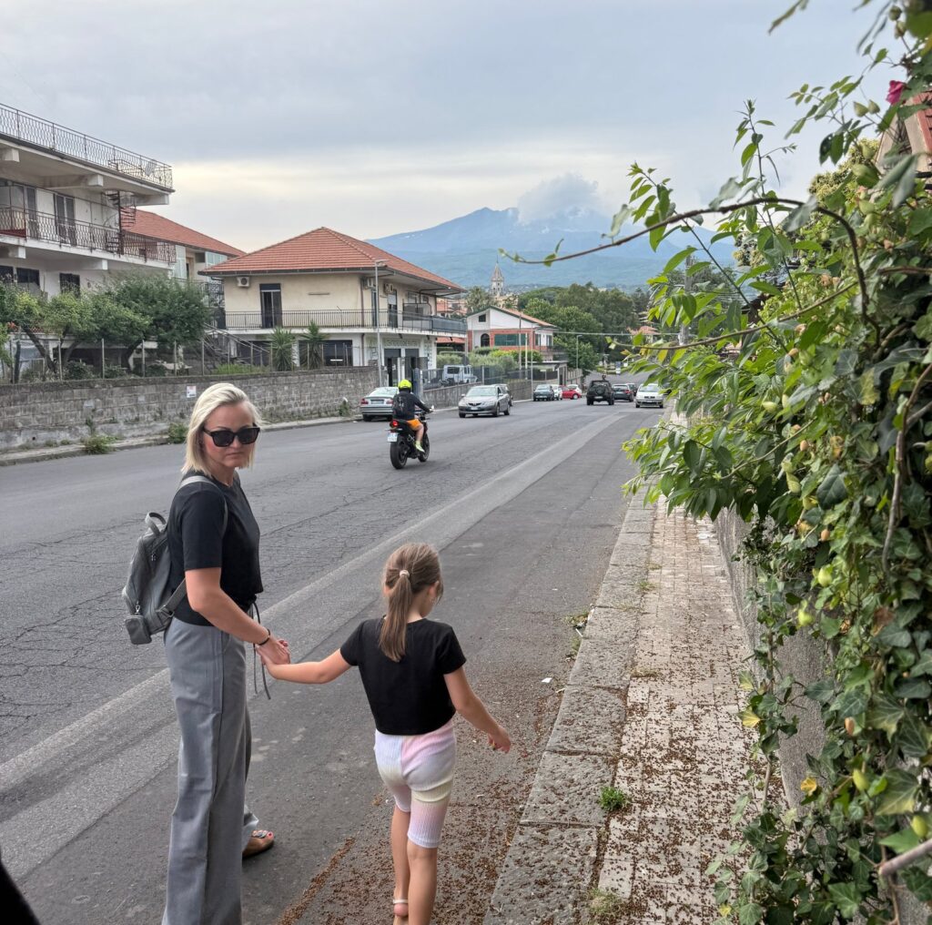 Ulica w Trecastagni z widokiem na Etnę w chmurach